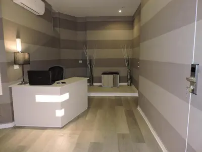 an office with a white desk and a striped wall at san cosimato suite in Rome