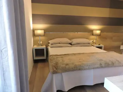 a bedroom with a bed and two lamps on two tables at san cosimato suite in Rome