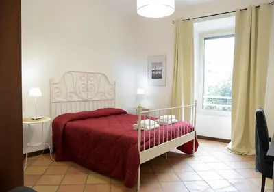 a bedroom with a bed with a red blanket and a window at Colosseum Comfortable Apartment in Rome