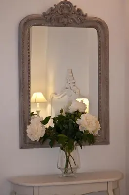 a vase of flowers on a table in front of a mirror at B&B La finestra sul Colosseo in Rome