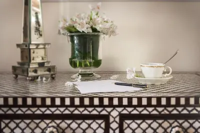 a table with a vase of flowers and a cup of coffee at Il Palazzetto in Rome