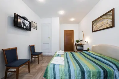 a hotel room with a bed and two chairs at Ai Musei Vaticani BB in Rome