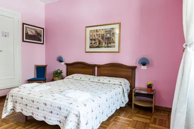 a bedroom with a bed and a pink wall at Ai Musei Vaticani BB in Rome