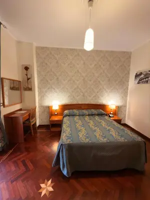 a bedroom with a bed and a table and two lamps at Hotel Domus Praetoria in Rome