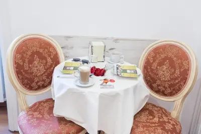 a table with two chairs with a white table cloth and coffee cups at Domus Giulia in Rome