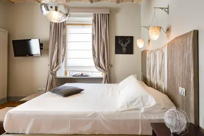 a bedroom with a large white bed and a window at Rooms Roma - Monti in Rome