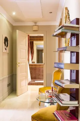 a living room with a glass table and a chair at Rooms Roma - Monti in Rome