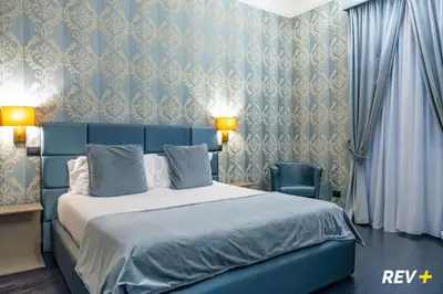 a bedroom with a bed and a blue wall at Via Veneto Suites in Rome