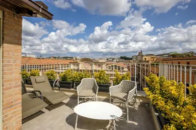 a balcony with chairs and a table and a view at Hotel Regno in Rome