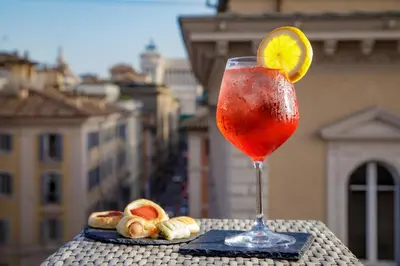 a drink sitting on a table with a slice of lemon at Hotel Regno in Rome