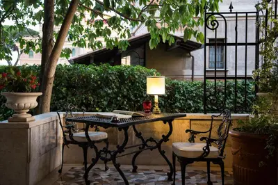 a table with two chairs and a lamp on a patio at Suite Oriani in Rome