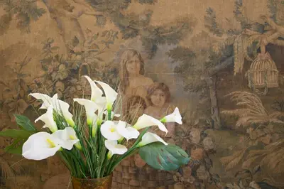 a vase with white flowers in front of a painting at Suite Oriani in Rome