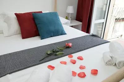 a bed with red roses and towels on it at Monti Central Apartment in Rome