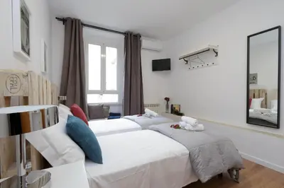 a bedroom with two beds and a mirror at Monti Central Apartment in Rome