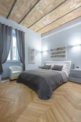 a bedroom with a large bed and a wooden floor at Sylvia Stylish Vatican Apartment in Rome