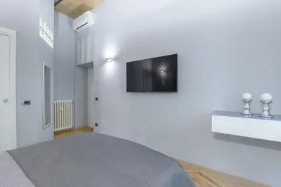 a bedroom with a bed and a tv on the wall at Sylvia Stylish Vatican Apartment in Rome