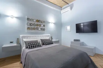 a bedroom with a bed and a flat screen tv at Sylvia Stylish Vatican Apartment in Rome