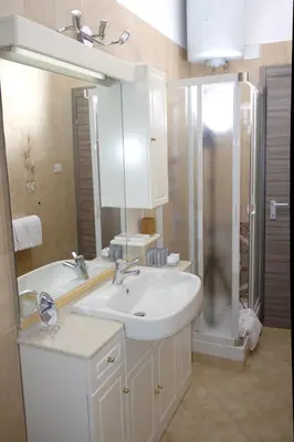 a white bathroom with a sink and a shower at In vacanza da Sara in Rome