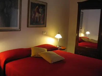 a bedroom with a red bed and a mirror at La Rotella Nel Sacco in Rome