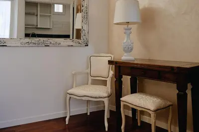 a desk with two chairs and a lamp and a mirror at Cozy Studio Parlamento in Rome