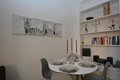 a dining room with a white table and chairs at Vatican Corner Family Apartment in Rome