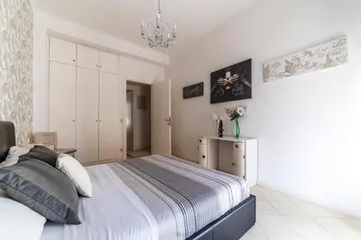 a bedroom with a large bed and a chandelier at Vatican Corner Family Apartment in Rome