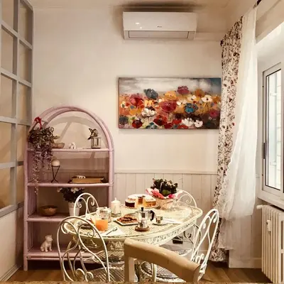 a dining room with a table and a painting on the wall at Delicious House in Rome