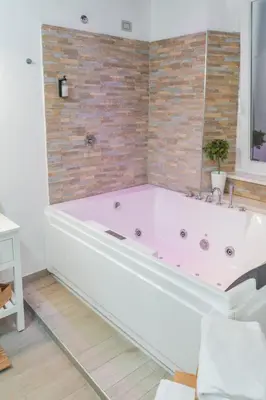 a bath tub in a bathroom with a brick wall at iRooms - Spanish Steps in Rome