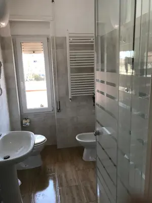 a bathroom with a sink and a toilet and a window at Juna's guest house in Rome
