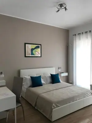 a bedroom with a large bed with blue pillows at Juna's guest house in Rome