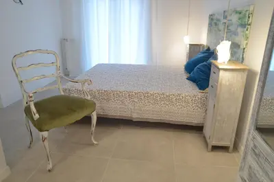 a bedroom with a bed with a chair and a dresser at Tempo Lento in Rome