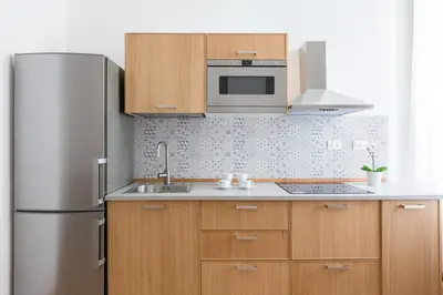 a kitchen with wooden cabinets and a stainless steel refrigerator at The Regal Suite in Rome