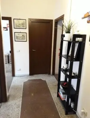 a hallway with a door and a shelf with books at EMI House Re di Roma, Intero Appartamento, 80 mq in Rome