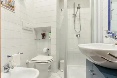 a white bathroom with a toilet and a sink at Enchanting loft in Trastevere in Rome