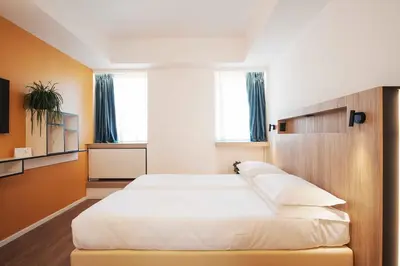a bedroom with a large white bed with blue curtains at Aparthotel Colombo Roma in Rome