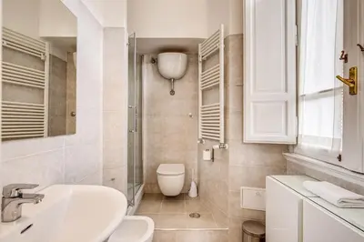 a white bathroom with a sink and a toilet at La casa di Nonna Pina in Rome