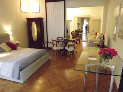 a bedroom with a bed and a living room at Penna Apartment in Rome