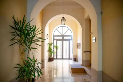 an arched hallway with a large window and plants at Romerooms in Rome