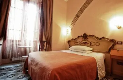 a bedroom with a bed in a room with a window at Maison de Marta in Rome