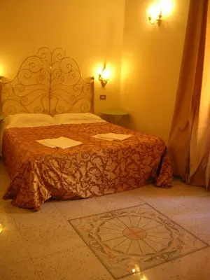 a bedroom with a bed with a orange bedspread at Maison de Marta in Rome