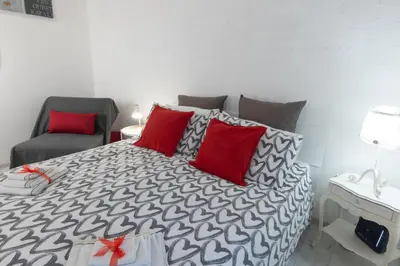 a bedroom with a bed with red pillows and a chair at Baglioni Vatican House in Rome