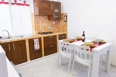 a kitchen with a white table with chairs and a sink at Baglioni Vatican House in Rome