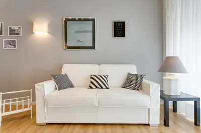 a white couch in a living room with a mirror at Goldie in Rome