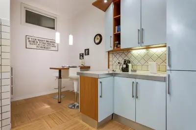 a kitchen with white cabinets and a counter top at Goldie in Rome