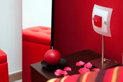 a red room with a red bed and a table with a mirror at La Casetta del Vaticano in Rome