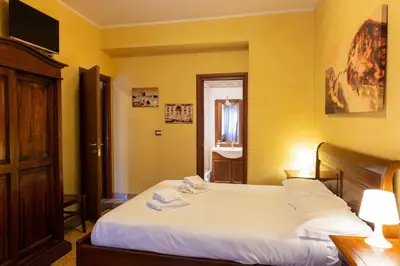 a bedroom with a bed and a bathroom with a sink at Cleopatra in Rome