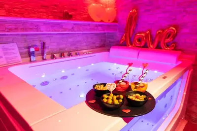 a bath tub with two bowls of fruit on a table next to it at Cleopatra in Rome