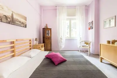 a bedroom with a large bed with a pink pillow on it at la casetta dei sogni in Rome