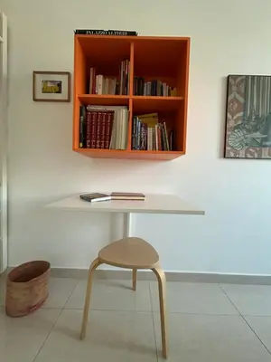 a table with a chair and a book shelf at La Riva Sinistra in Rome