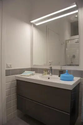 a bathroom sink with a blue soap dispenser on it at Colosseum View Exclusive Apartment in Rome